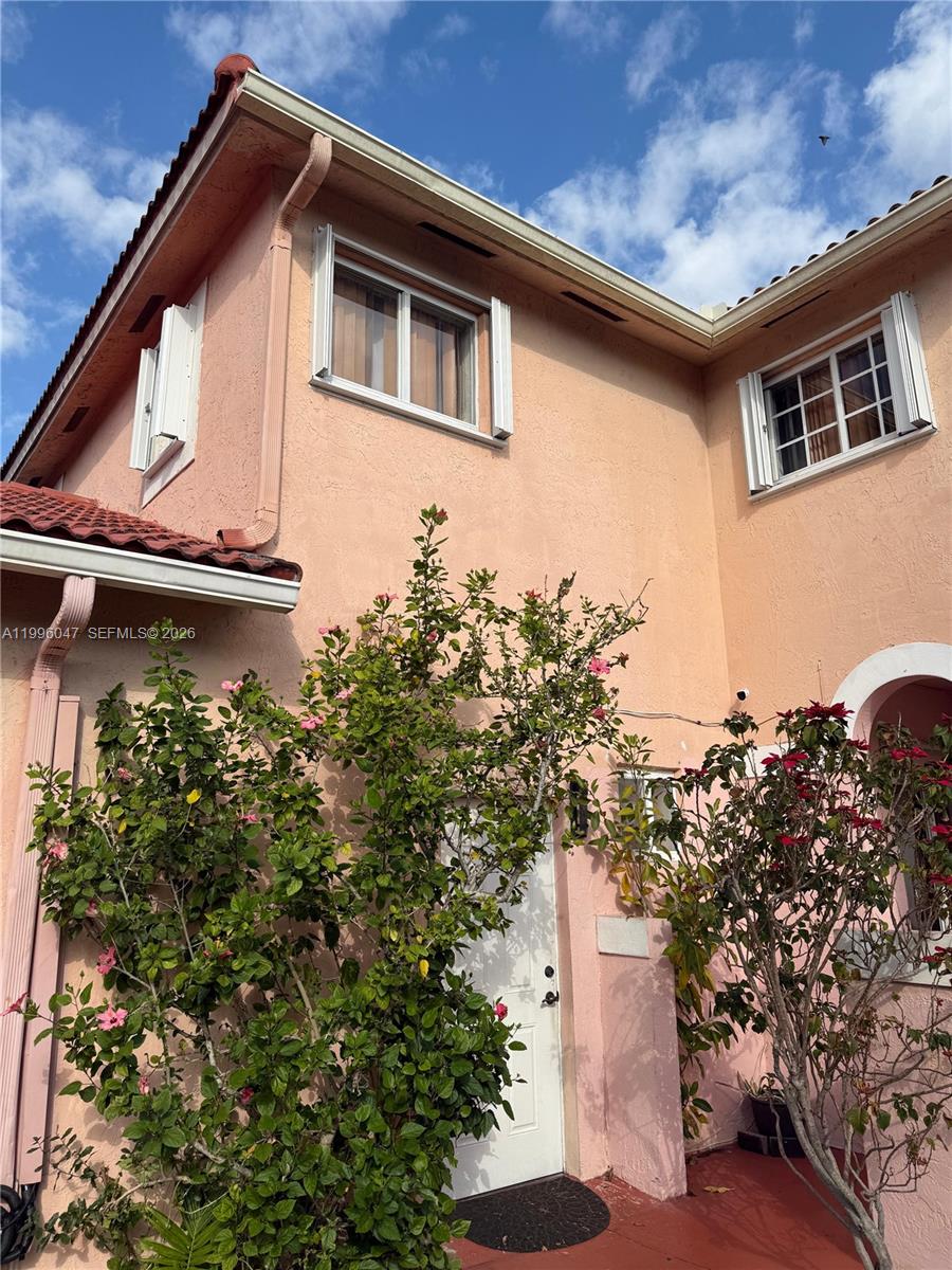7477 Northwest 167th Street Hialeah, FL 33015 - Photo 3 of 24 a view of a house with a yard and garage