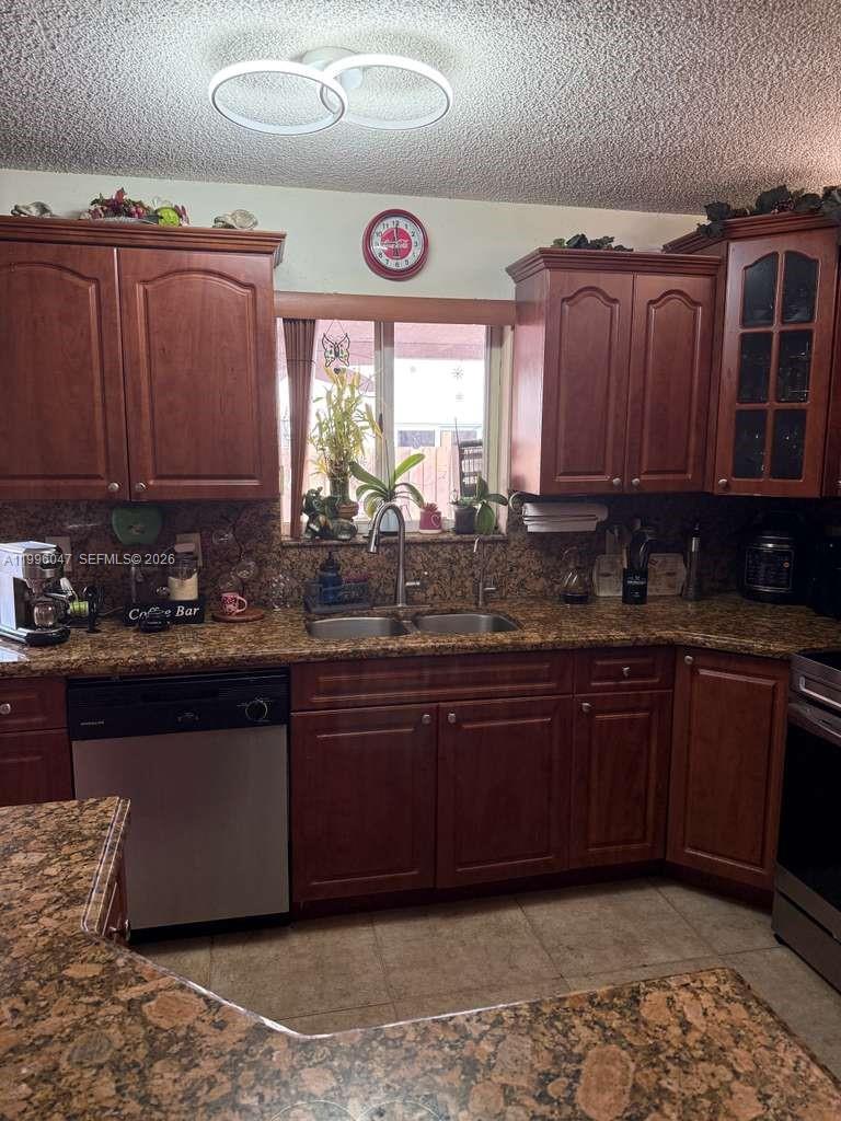 7477 Northwest 167th Street Hialeah, FL 33015 - Photo 9 of 24 a kitchen with stainless steel appliances granite countertop a sink dishwasher stove and cabinets