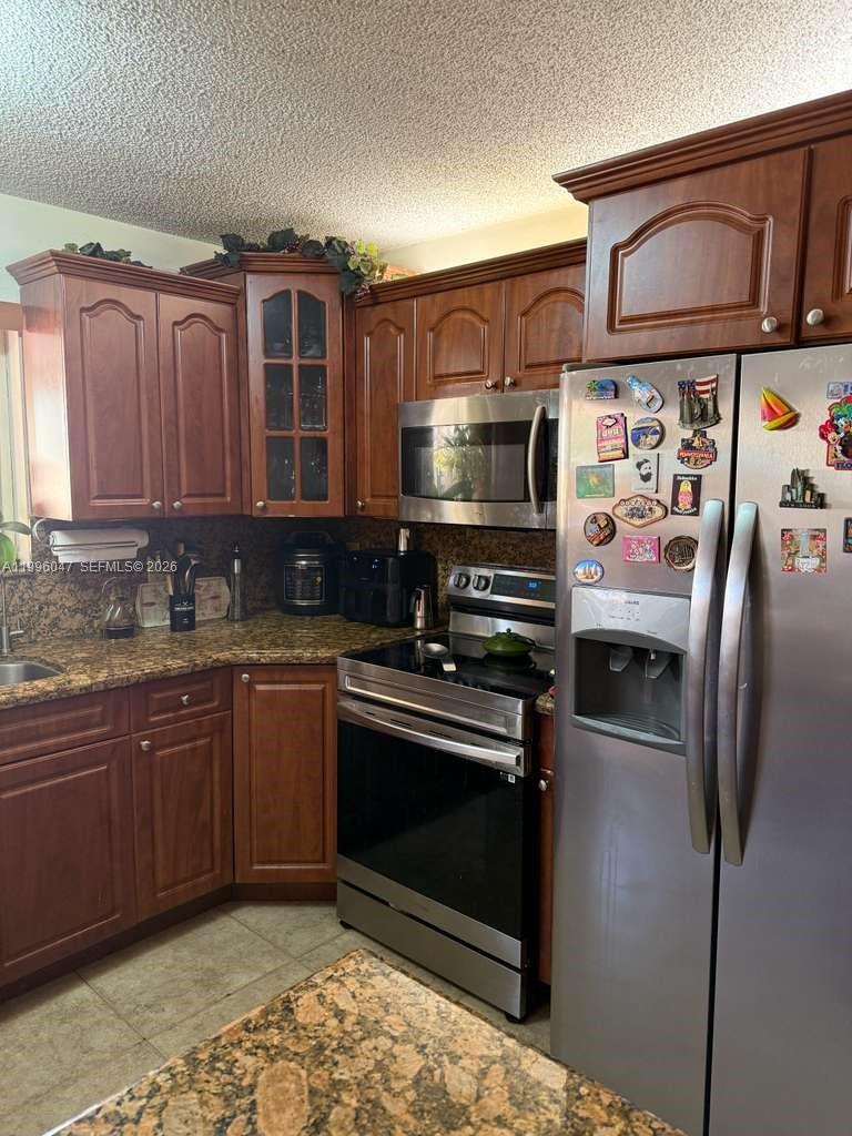 7477 Northwest 167th Street Hialeah, FL 33015 - Photo 10 of 24 a kitchen with stainless steel appliances granite countertop a refrigerator and a sink