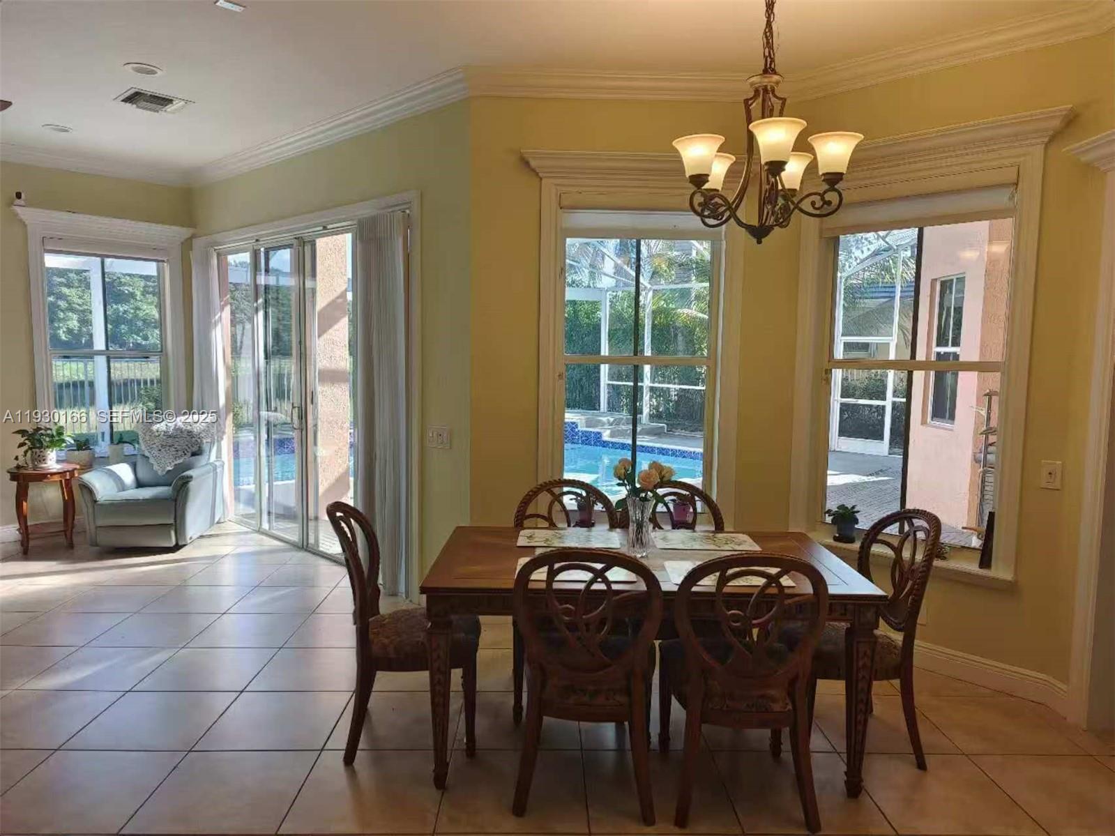 1035 Waterside Circle Weston, FL 33327 - Photo 11 of 40 a view of a dining room with furniture wooden floor and chandelier
