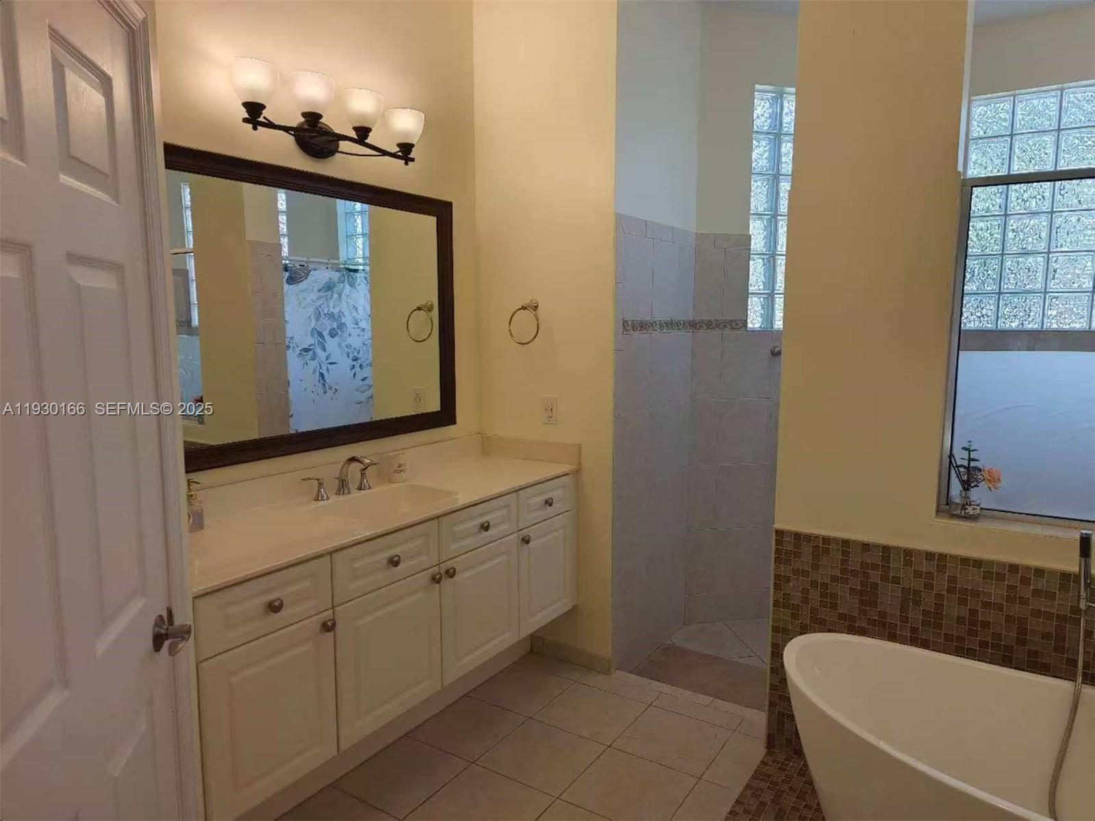 1035 Waterside Circle Weston, FL 33327 - Photo 12 of 40 a bathroom with a tub a sink and mirror