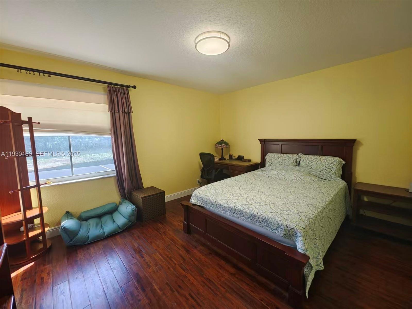 1035 Waterside Circle Weston, FL 33327 - Photo 15 of 40 a bedroom with a bed and wooden floor