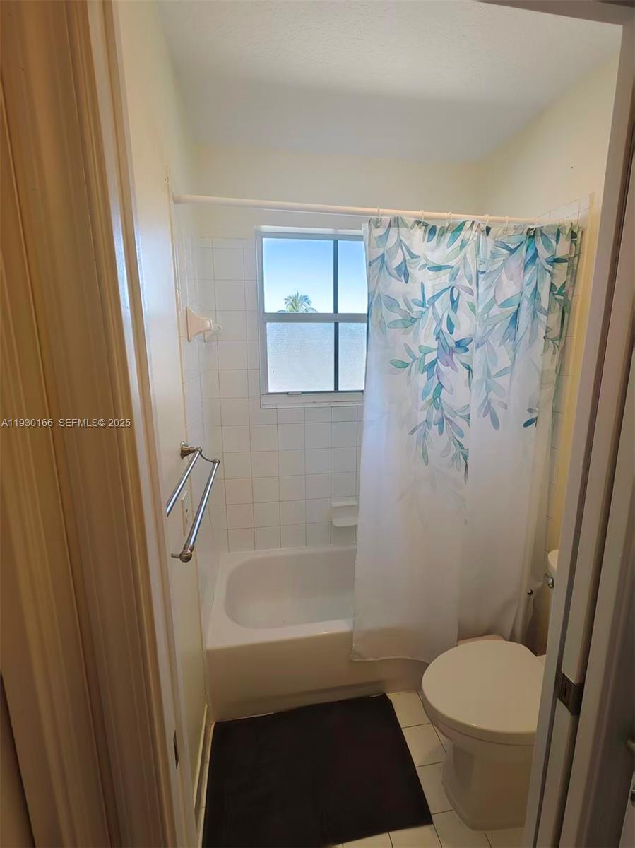 1035 Waterside Circle Weston, FL 33327 - Photo 20 of 40 a bathroom with a toilet and a shower curtain