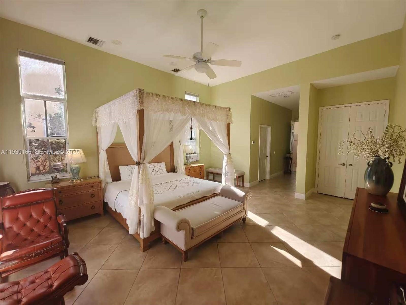 1035 Waterside Circle Weston, FL 33327 - Photo 7 of 40 a spacious bedroom with a bed and a chandelier