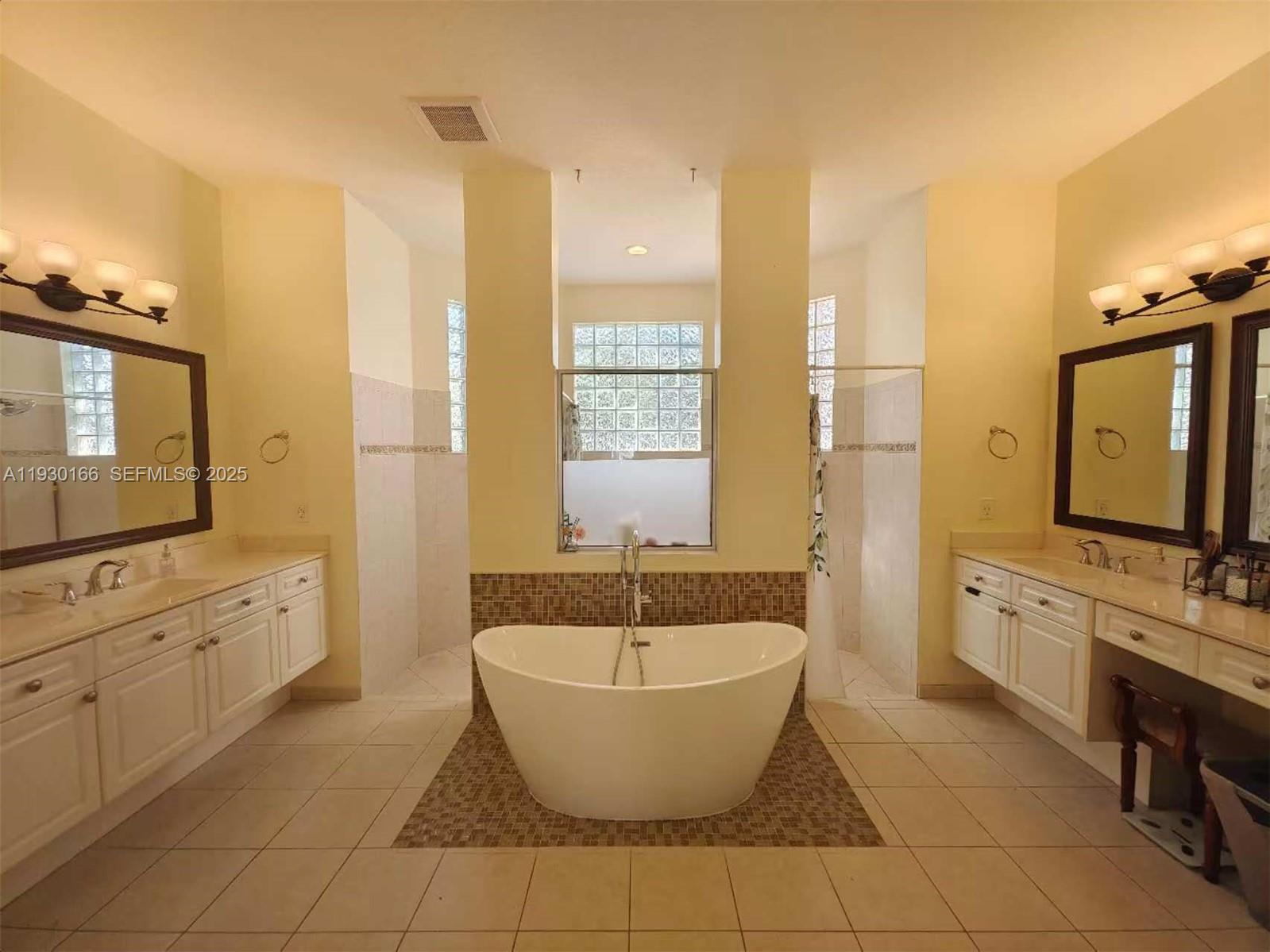 1035 Waterside Circle Weston, FL 33327 - Photo 8 of 40 a spacious bathroom with a granite countertop double vanity sink a mirror and a bathtub