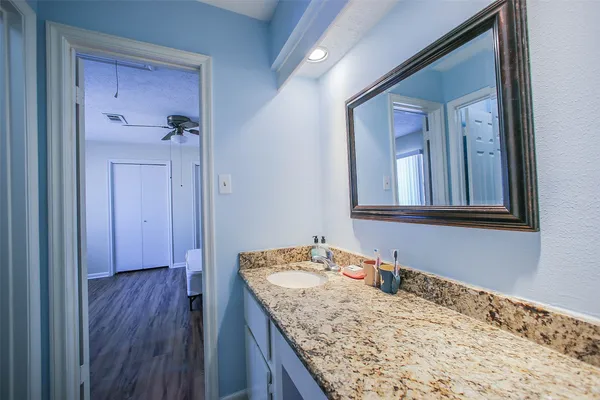a bathroom with a granite countertop sink and a mirror
