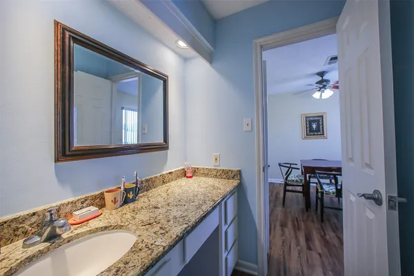 a bathroom with a granite countertop sink and a mirror