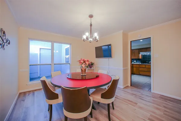 a dining room with furniture a chandelier and wooden floor