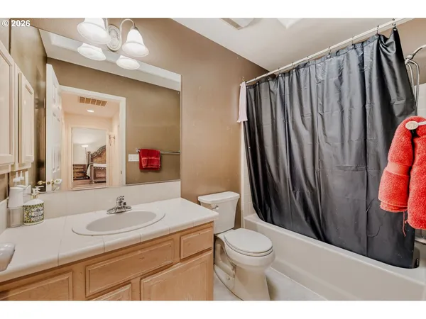 a bathroom with a sink a toilet a mirror and shower