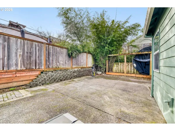 a view of backyard with potted plants and wooden fence