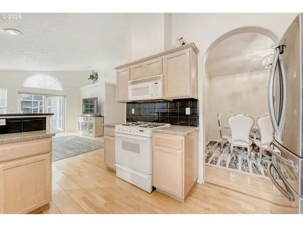 a kitchen view with appliances a counter space and cabinets