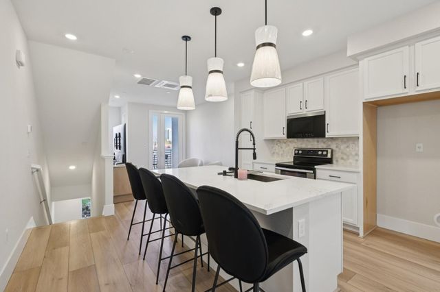 a kitchen with a table chairs sink and cabinets