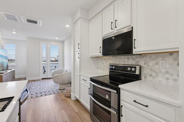 a kitchen with stainless steel appliances a stove microwave and cabinets