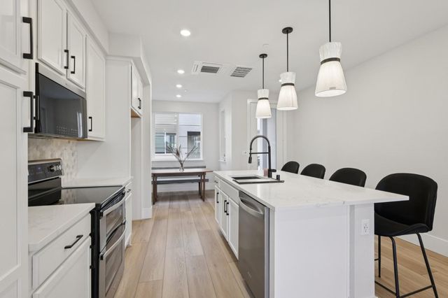 a kitchen with a table chairs and white cabinets