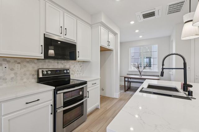 a kitchen with stainless steel appliances a stove sink and cabinets
