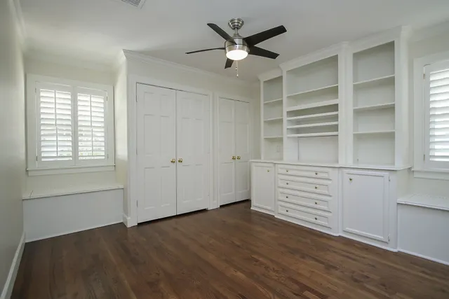 an empty room with cabinet and windows