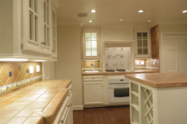 a kitchen with a stove and white cabinets
