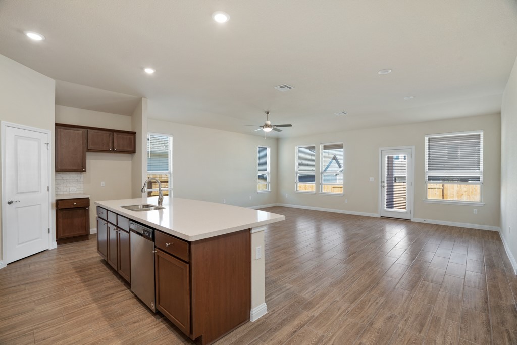 8202 Dampton Lane Austin, TX 78744 - Photo 5 of 25 a kitchen with stainless steel appliances granite countertop a wooden cabinets a sink dishwasher and a stove with wooden floor