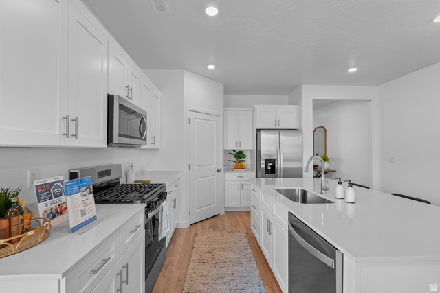 1589 South Fins Road, Unit 4178 Washington, UT 84780 - Photo 15 of 30 Modern kitchen featuring white shaker cabinetry, stainless steel appliances, quartz countertops, and wood-finish flooring