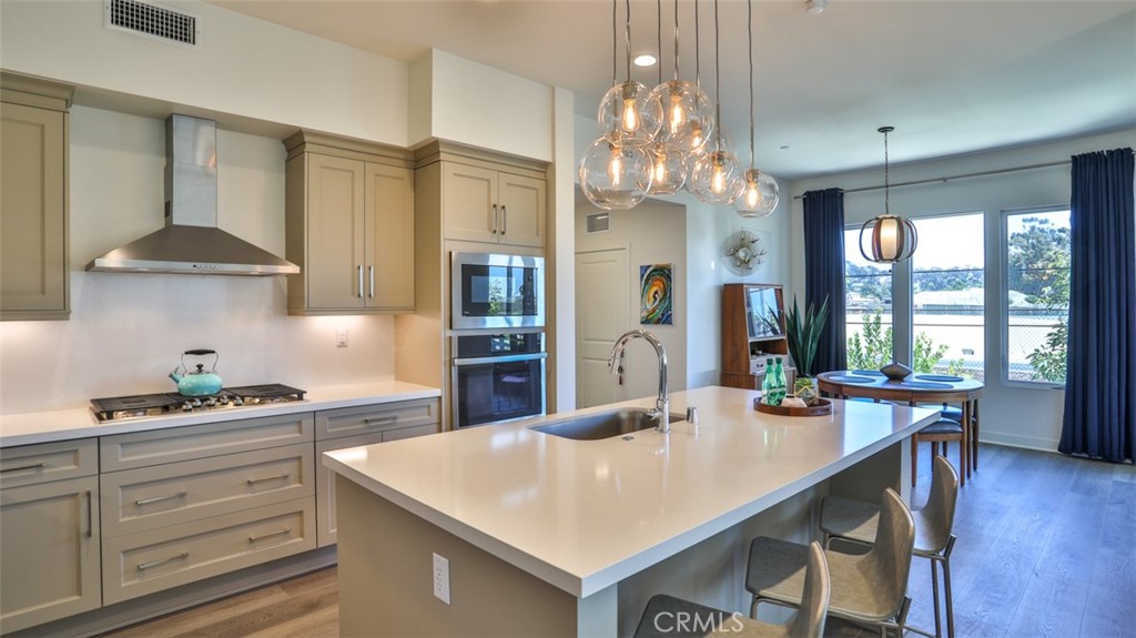 1207 Doheny Way Dana Point, CA 92629 - Photo 68 of 74 a kitchen with stainless steel appliances a table chairs and chandelier