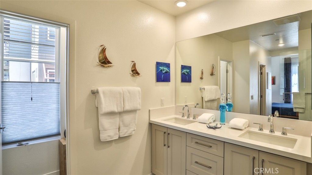 1207 Doheny Way Dana Point, CA 92629 - Photo 16 of 74 a bathroom with a double vanity sink and mirror