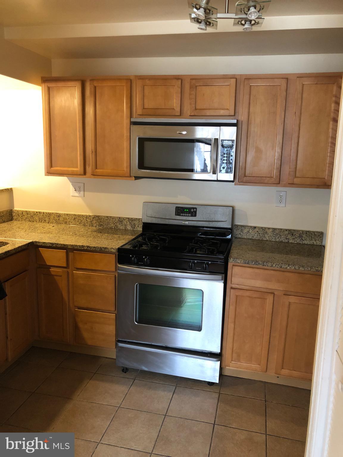 a kitchen with granite countertop a stove and a sink