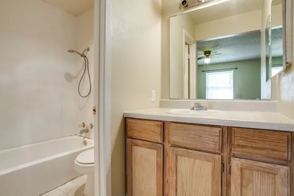 a bathroom with a granite countertop sink a toilet and shower