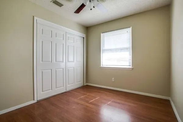 an empty room with windows and closet