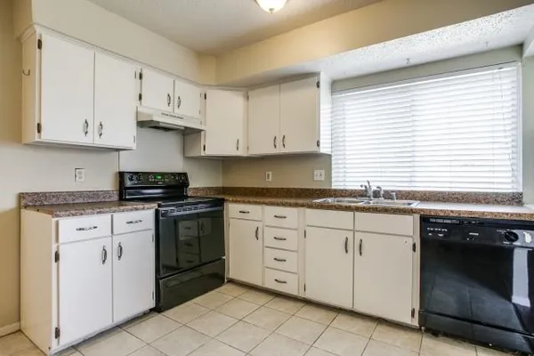 a kitchen with granite countertop white cabinets and white appliances