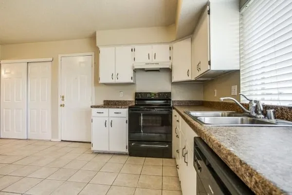 a kitchen with a sink stove and cabinets