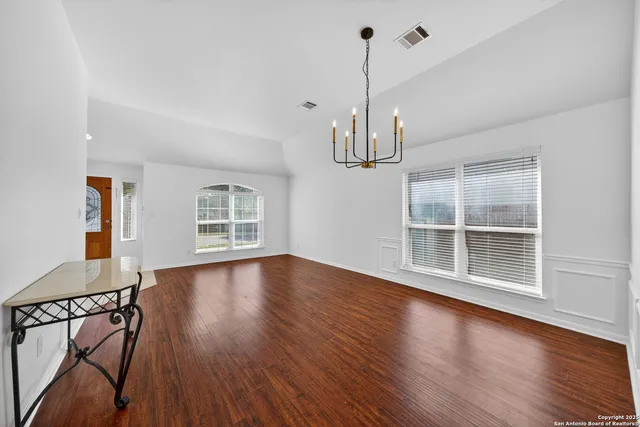 a view of empty room with wooden floor and window