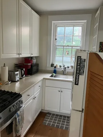 a hallway with wooden floor and a large mirror on a dresser