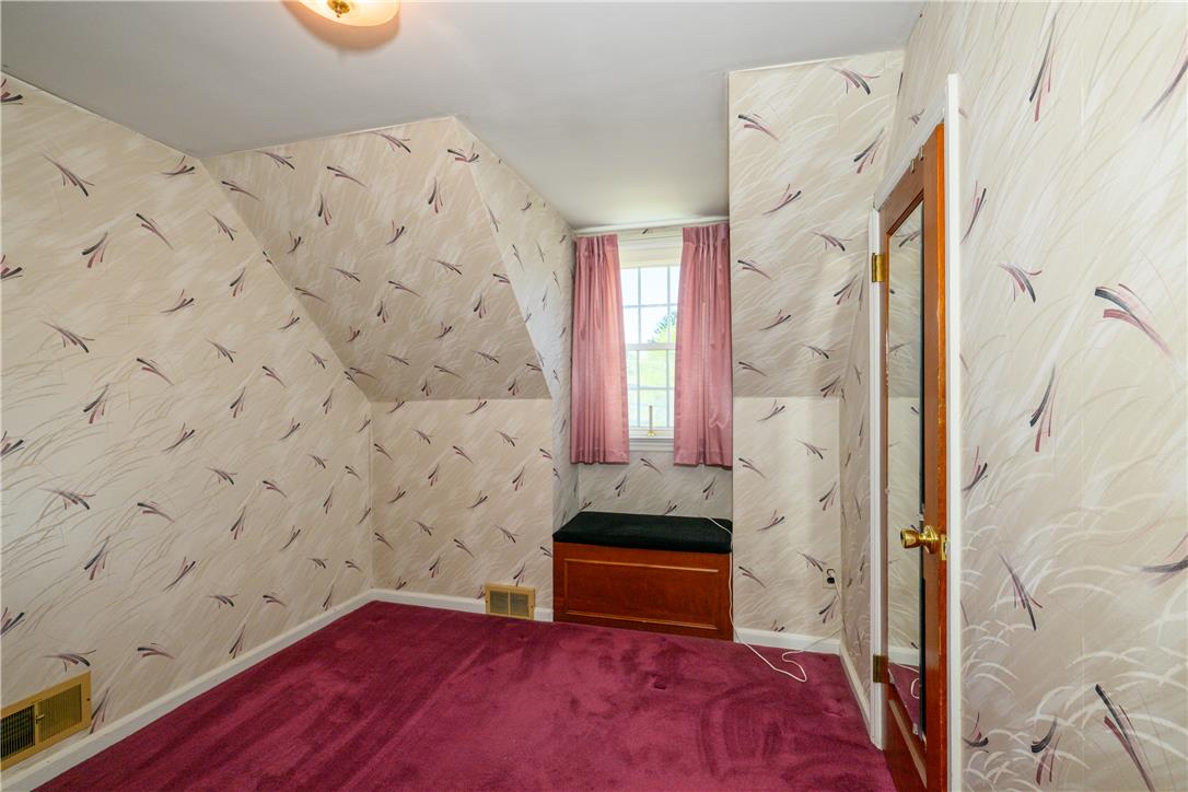 2270 Rodgers Street Bethlehem, PA 18017 - Photo 13 of 24 This cozy bedroom features sloped walls and a vibrant carpet, creating a unique and inviting space.