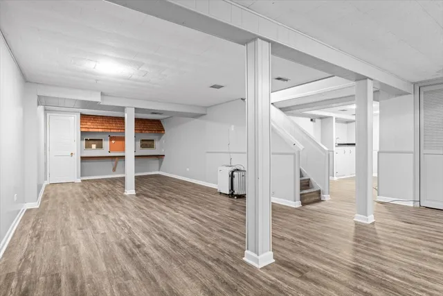a view of empty room with wooden floor and window