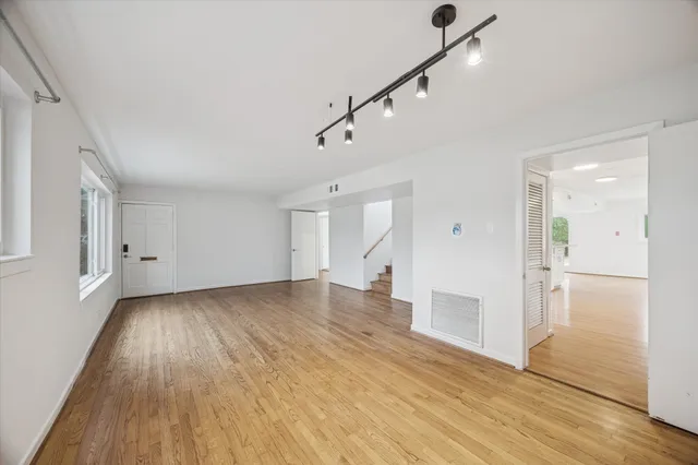 an empty room with a window and ceiling fan
