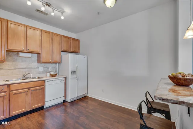 a kitchen with stainless steel appliances granite countertop a stove a sink and white cabinets with wooden floor