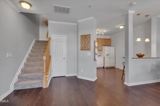 a view of a hallway with wooden floor and staircase