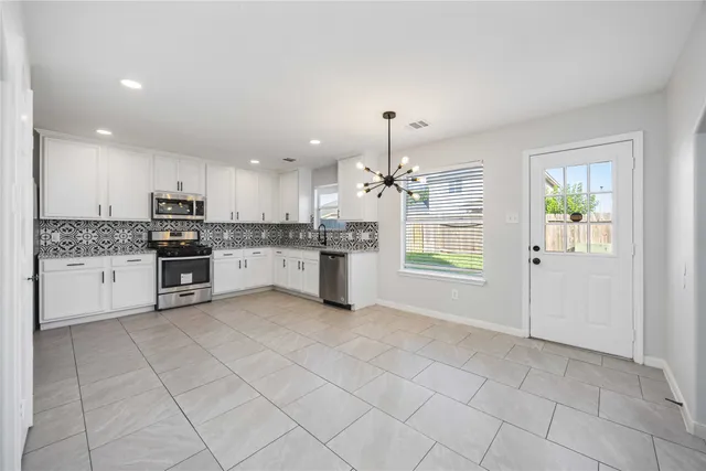 a kitchen with stainless steel appliances granite countertop a refrigerator sink and cabinets