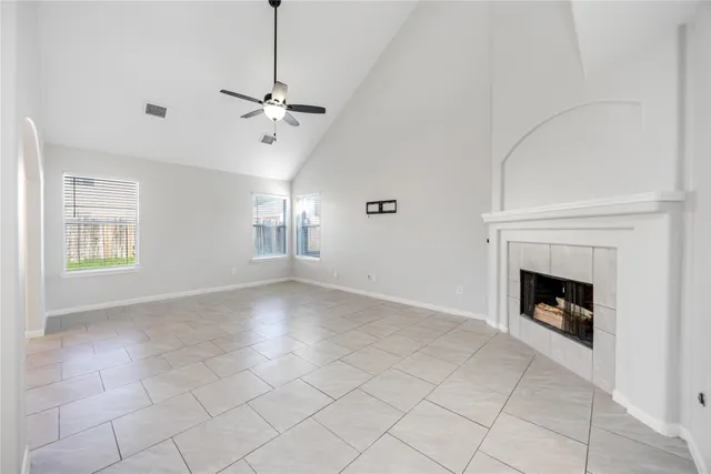 an empty room with windows and fireplace