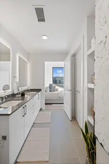 a large white room with a sink and mirror with window