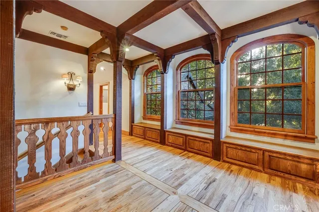 a view of hallway with wooden floor and cabinet