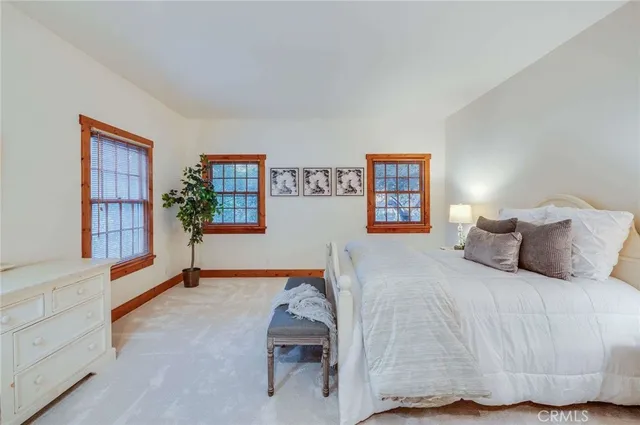 a bed sitting in a spacious bedroom next to a window