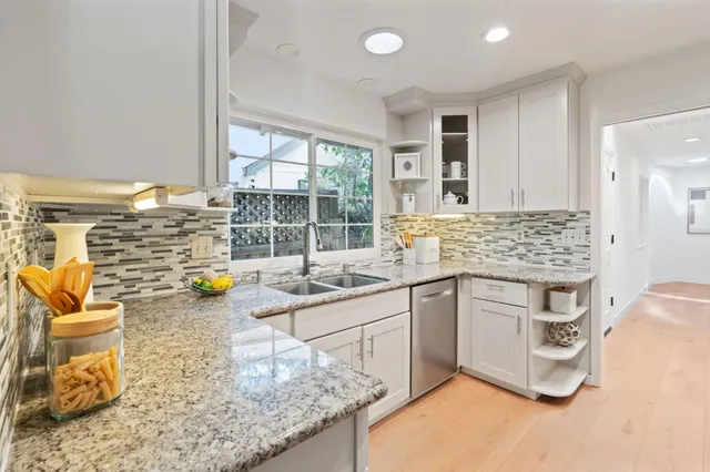 a kitchen with sink a stove and cabinets