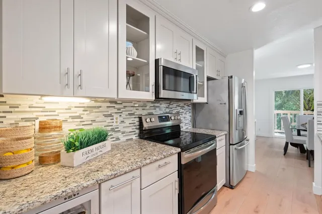 a kitchen with stainless steel appliances granite countertop a stove and a sink