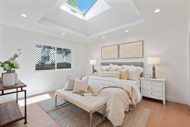 a bedroom with a bed a mirror and lamp