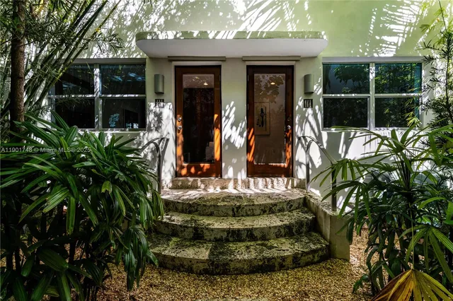 a view of a house with a yard and potted plants