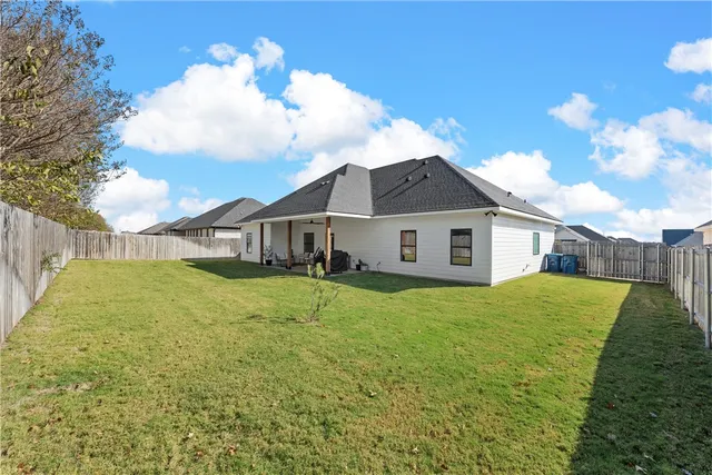 a view of a yard in front of a house with a large tree