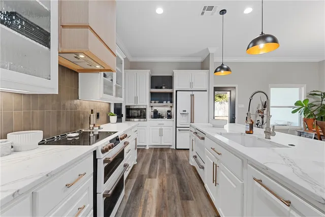 a kitchen with stainless steel appliances a sink a stove and a wooden floors