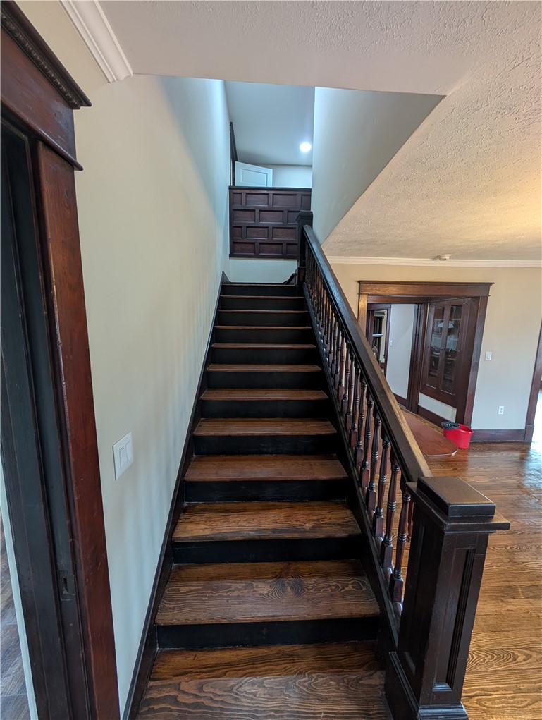 10796 Preble County Line Road Brookville, OH 45309 - Photo 15 of 33 Rich wood staircase with elegant railings ascends to a brightly lit upper landing.
