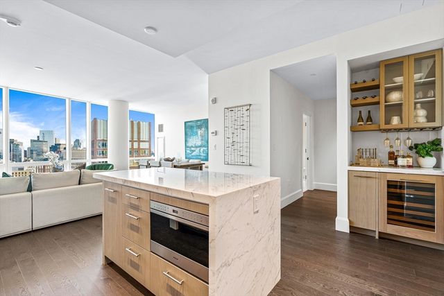 a large white kitchen with stainless steel appliances and white cabinets